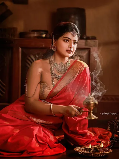 The gentle smoke from the incense adds a layer of mystique and sanctity to this portrait. It's a sensory image, capturing not just the visual beauty of the bride but also the sacred atmosphere of the moment.