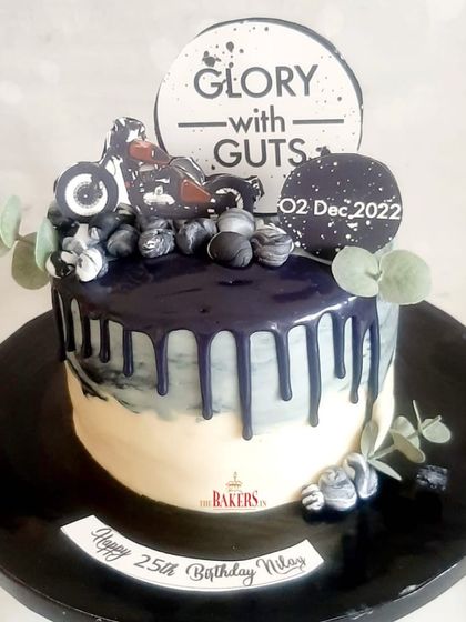 A cool, no-fondant bike-themed cake for a 25th birthday. The black and grey marble effect with a dark drip gives it a masculine and modern vibe. The flavor was mocha and salted caramel.