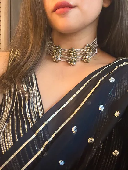 A close-up of the dual-tone ghungroo choker I paired with my black mul cotton saree. This kind of accessory is versatile and adds a touch of traditional charm to a modern look.