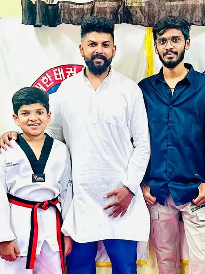 A student celebrates his new red and black belt.
