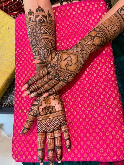 Another angle of the personalized back-hand design. The initials are framed by intricate patterns, and the arms feature architectural and floral motifs.