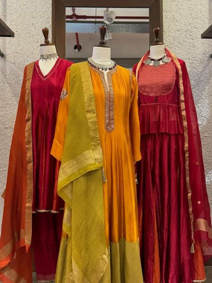 A full view of the festive red and orange collection, showcasing the flowing silhouettes and rich colors.