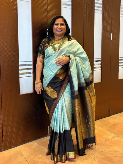 Our client Veena in a designer silk saree with a breathtaking combination of light blue and black.