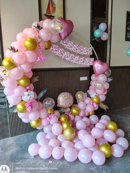 A simple and sweet Naming Ceremony decoration with a pink and gold balloon ring.