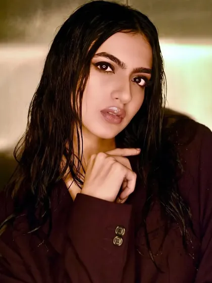 A color portrait that highlights the glossy finish on the lips and the subtle warmth of the skin, contrasting with the cool, dark tones of the eye makeup.