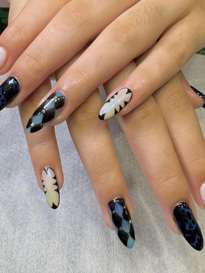 A full view of the finished graphic nail art set. The combination of different patterns on each nail creates a cohesive yet eclectic and personalized manicure.