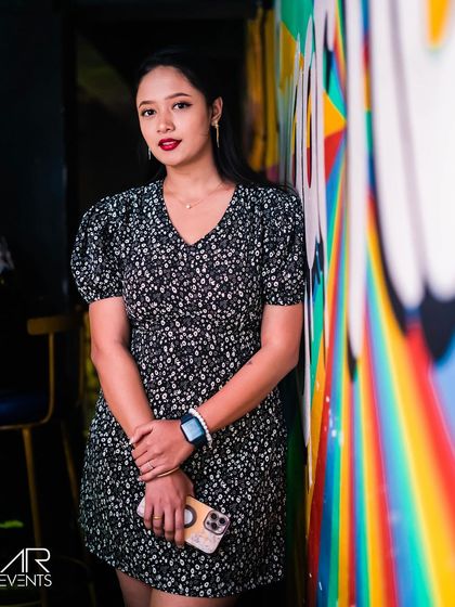 A guest posing against a colorful wall mural.