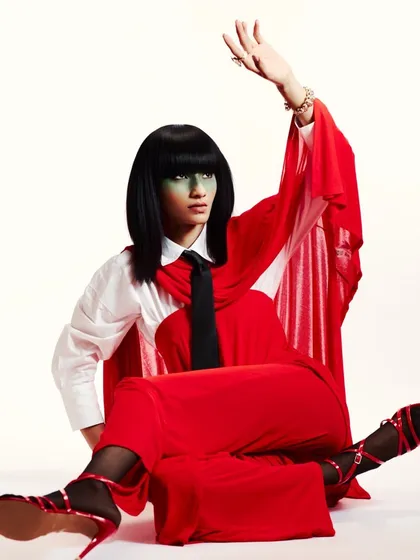 Another angle from the red and green editorial, showcasing the pose and the interaction between the styling and the bold makeup.
