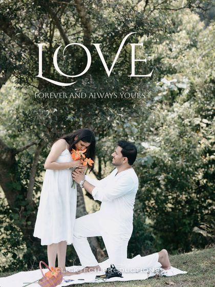 A classic proposal pose on a picnic blanket in Coorg, with the groom on one knee, presenting flowers to the bride.