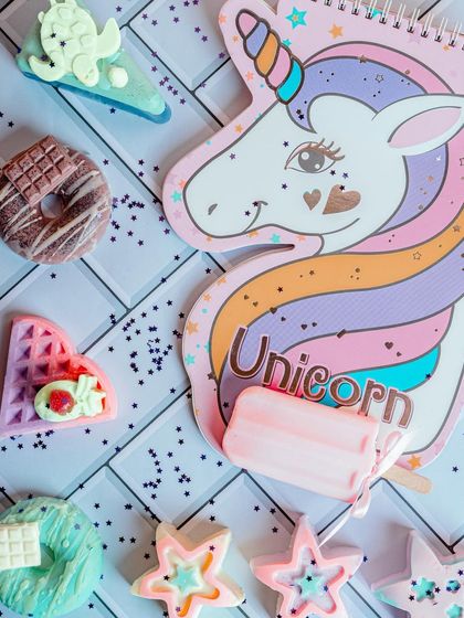 My handmade soaps are a popular choice for kids' party favors and gifts. This flat-lay shows a variety of fun shapes like unicorns, donuts, waffles, and stars, all made with gentle, kid-safe ingredients.