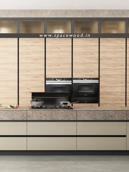 This design features a wall of floor-to-ceiling cabinets with a natural wood finish, seamlessly integrating the double ovens and hob. The large island has a stone-textured countertop, providing a durable and stylish surface for all your cooking needs.