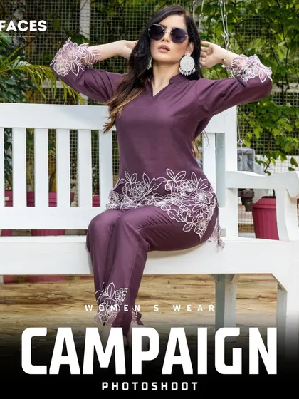 A model wearing sunglasses and a purple embroidered suit sits on a white bench outdoors. This shot blends traditional attire with modern styling to create a chic, contemporary fashion statement.