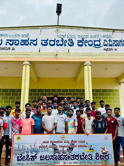 A proud group photo of participants and instructors in front of the Aqua Sports Training Center at Vani Vilas Sagara.