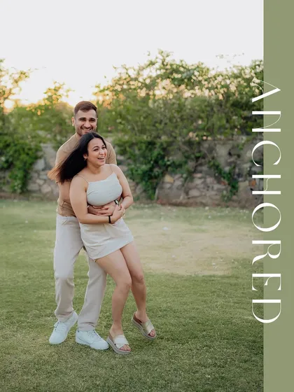 A playful and joyful moment captured in a park, with a stylish "Anchored" text design.