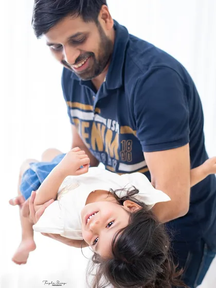 A playful moment with dad holding his daughter upside down. I love capturing the fun and laughter that is so central to family life.