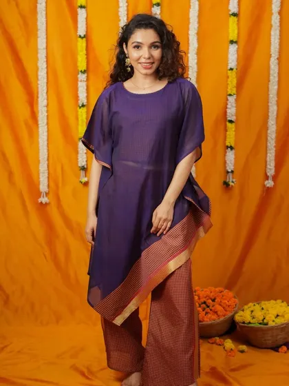 An asymmetrical kaftan-style kurta paired with palazzo pants. This modern silhouette combines comfort with a chic design, featuring a traditional border for a touch of ethnic flair.