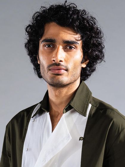 For this look, we styled the model's hair to emphasize its natural volume and texture, paired with subtle makeup to ensure the focus remains on the apparel.