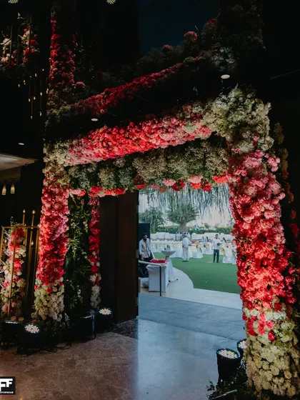 Making a grand statement from the very first step. This immersive floral entrance arch, crafted with thousands of red and pink blooms, welcomes guests into a world of celebration and wonder.