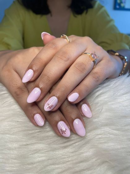 A beautiful "Grape Milk" gel polish manicure with a subtle, shimmery floral decal on the ring finger.