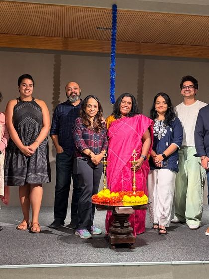 A group of event organizers and speakers smiling for a photo on stage, marking a successful launch.