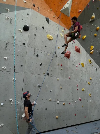 A climber takes a moment to rest and shake out before tackling the next section of a challenging lead route.