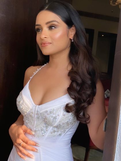 The soft, flowing hair adds a touch of romance to her stunning bridal look.