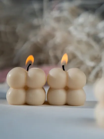 Cute little mini bubble candles, lit and glowing. They are perfect for adding a small, charming touch to any corner of your home.
