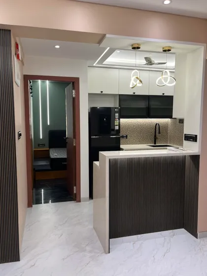This view shows how an open kitchen can be beautifully integrated with the living area. The fluted paneling on the breakfast bar adds texture and sophistication, connecting the two spaces.