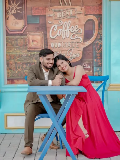 A cozy and romantic moment at a cafe-themed set. The couple's intimate pose and the charming background create a sweet, story-driven image perfect for their pre-wedding album.