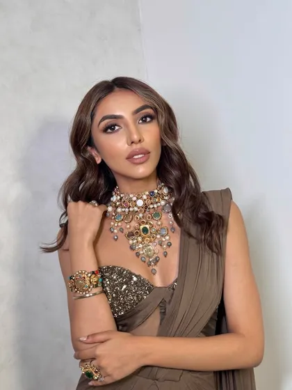This portrait showcases the beautiful harmony between the makeup, the intricate jewelry, and the earthy tones of the outfit.