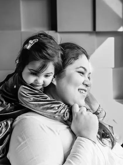 A tender black and white moment between a mother and her child. The hug from behind and their happy smiles create a timeless portrait of maternal love.