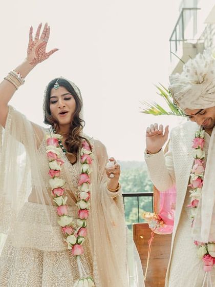 A moment of pure fun and spontaneity during the Varmala ceremony. The couple's dance moves show their playful personalities and the joyful spirit of their wedding.