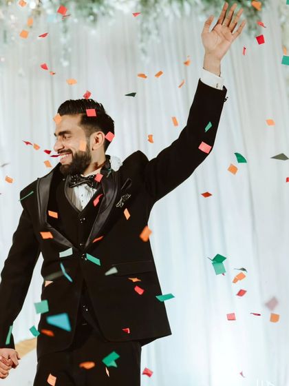 The groom, Ryan, celebrates under a shower of confetti. Capturing these moments of individual joy is just as important as the couple's shots.
