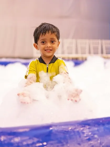 This picture is pure happiness. A young guest enjoying the foam pit at our pool party, completely lost in the moment. Creating these joyful experiences is why I do what I do.
