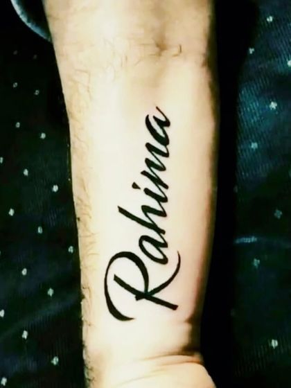 A name tattoo, "Rahima," in a flowing script on the forearm.