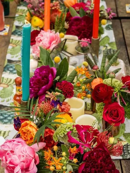 A burst of color on the table. This vibrant tablescape uses a mix of bright flowers and colorful candles to create a festive and energetic mood, perfect for a lively celebration.