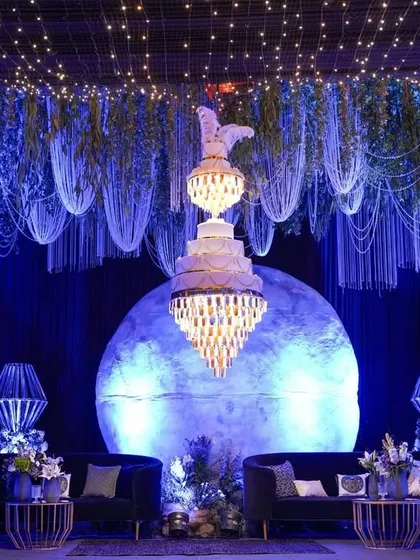 The celestial lounge stage, featuring a large glowing moon, a magnificent tiered chandelier, and a ceiling of hanging pearls and fairy lights.