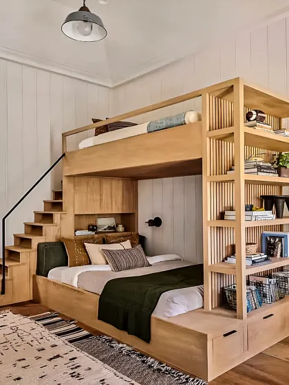 For this kids' bedroom, I focused on creating a fun, space-saving environment. This custom wooden bunk bed includes stairs that double as storage drawers, making the most of a compact room while adding a playful touch.
