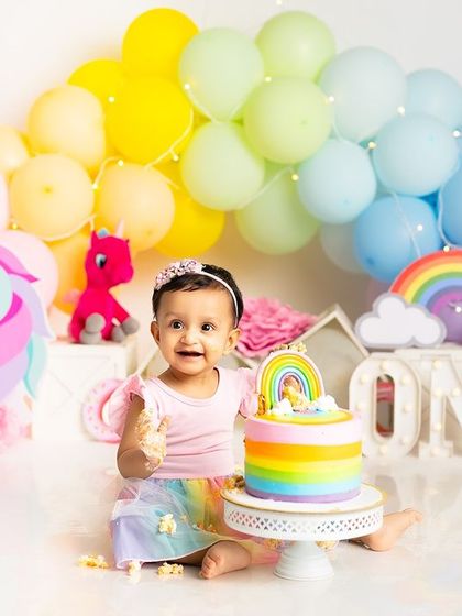 A perfect bite of birthday cake! This photo captures the sweet taste of celebration during a colorful unicorn-themed first birthday session.