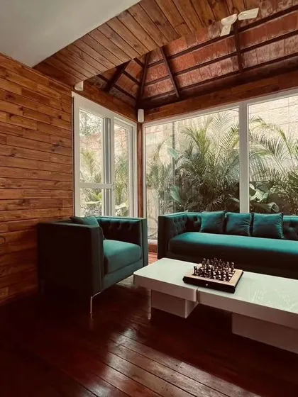 This beautiful sunroom, part of a project for Mr. Amar Nagaram, founder of Virgio, blurs the line between indoors and outdoors. Featuring Brazilian Ipe wood flooring and a traditional Mangalore tile roof, it’s a warm, inviting space to relax while surrounded by greenery.