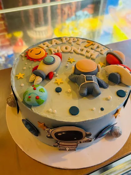 A 7-month milestone cake with a fun outer space theme, complete with an astronaut, rocket, and planets.