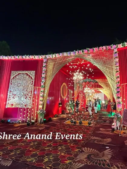 An ornate entrance archway with intricate gold weaving, floral borders, and a glimpse of the grand celebration inside.