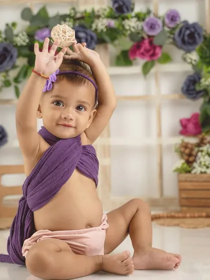 A playful and interactive moment from a first birthday session. Her happy expression is absolutely infectious.