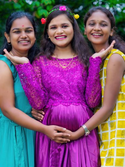 A maternity shoot can also be a celebration with your support system. Here, the mom-to-be is surrounded by her smiling sisters or friends, sharing in her happiness.