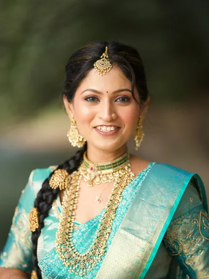 I love exploring the rich traditions of India, like this classic South Indian bridal look. This close-up highlights the intricate gold jewelry, a traditional braided hairstyle with floral accessories, and makeup that emphasizes radiant, glowing skin.