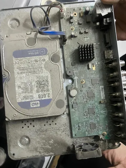 This is the inside of a poorly maintained DVR. The buildup of dust and dirt on the hard drive and motherboard can lead to overheating and complete system failure.