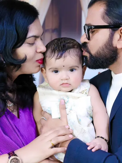 A close and intimate family portrait, with both parents kissing their baby. These are the moments to treasure.