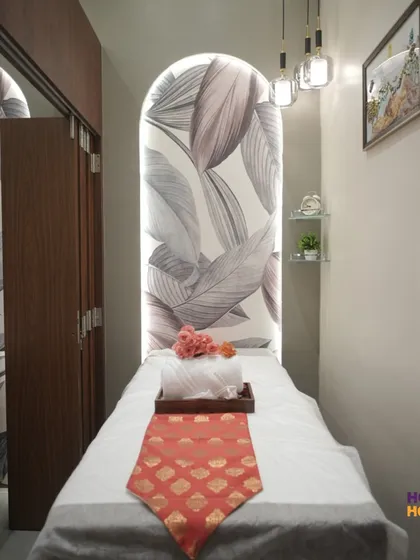In this spa treatment room, a backlit arched wall with a botanical print serves as a serene focal point. We combined this with rich wood cabinetry and soft pendant lighting to create a private, peaceful sanctuary for guests.