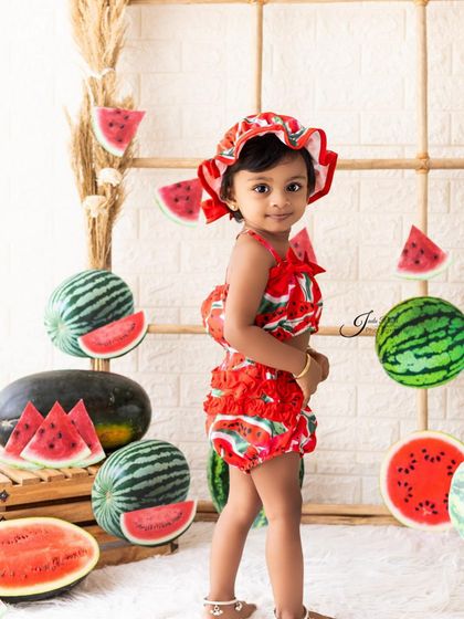 Dressed in a cute watermelon-print outfit with a matching hat, this little one is ready for her fruit-themed party. I provide themed costumes for many of my creative shoots.