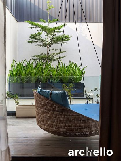 A simple hanging swing chair on a private balcony offers a perfect escape. This detail from our 'Indian Modern House' project, featured in Archello, shows how even small spaces can be transformed into personal retreats for relaxation.